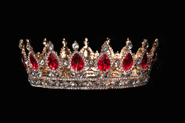 Red crown with red gems isolated on black background