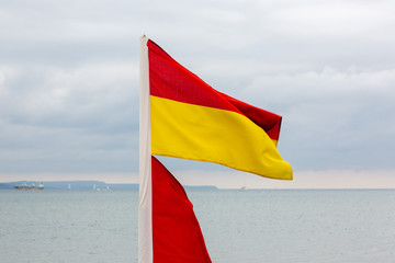 Red and yellow lifeguards flag on beach