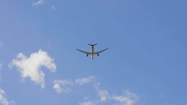 Commercial passenger airplane flying overhead on sunny day. UltraHD stock footage.