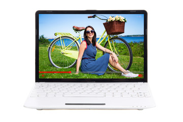 travel blog concept - beautiful girl with bicycle on laptop screen