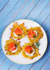 Potato Pancakes With Smoked Salmon. Vegetable fritters with fish. Latkes on a plate. View from above, top studio shot
