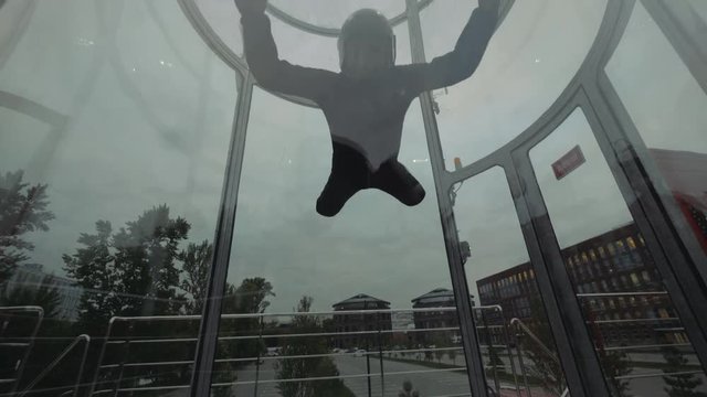Man skydiver fly into wind tunnel up and down. Flying in a skydiving tunnel