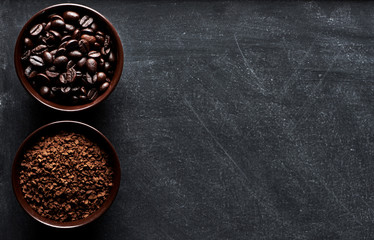 Coffee types: beans and instant in cups on dark board with copy space for text. 