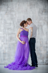 Fototapeta na wymiar pregnant woman and man posing together in the Studio