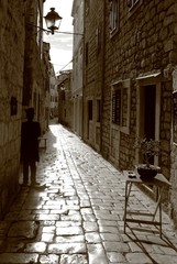 Silhouettes and shadows in old stoned street in Stari Grad town, Island Hvar, Croatia