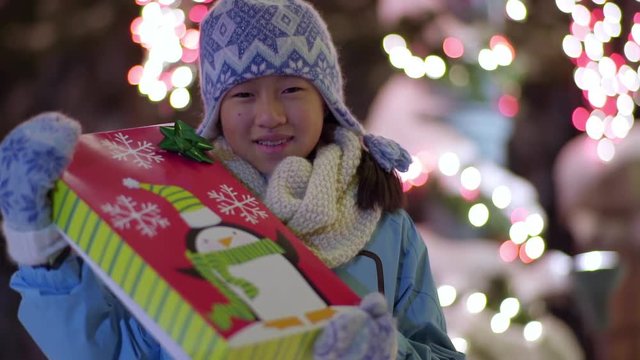 Portrait Of Happy Little Girl Holding A Wrapped Christmas Present (Slow Motion)
