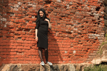 Portrait of young beautiful white girl with aristocratic features with long black hair and in black...