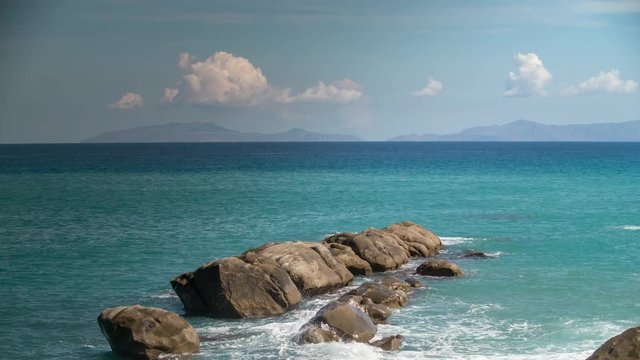timelapse of a rock and Mediterranean sea with the volcanic aeolian islands in the distance in Sicily, Italy.