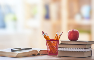 Apple, pile of books and pencils