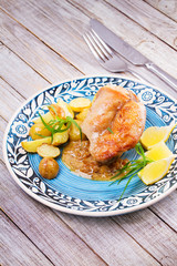 Rabbit with potatoes and lemon in cream sauce, garnished with tarragon