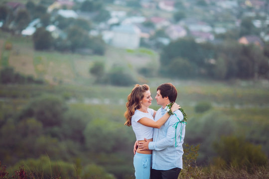 Romantic couple at sunset on bright yellow sky and city background, love tenderness concept, young adult people