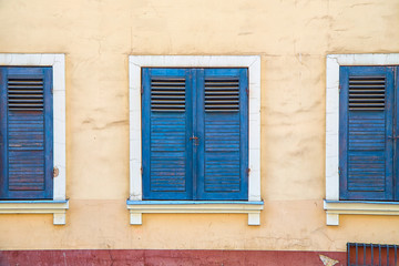 Closed windows with old blue shutters. Part of the facade of the building in the old town Riga, Latvia