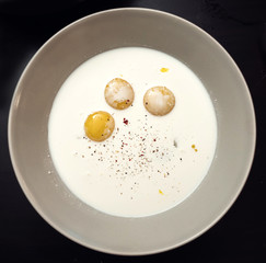 Three broken chicken eggs in a plate with milk and spices. Making an amlet.