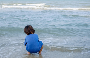 little boy playing sand on the beach.