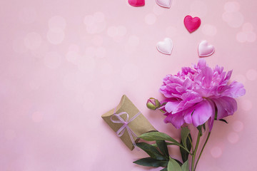 Romantic background with peony, gift box and hearts on pink.