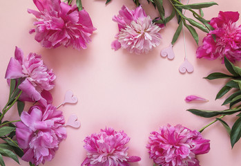 Frame of pions and decorative hearts on a pink background. Place for the text.