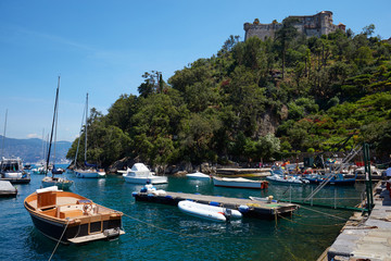 Fototapeta na wymiar Portofino small harbor with green water and Castello Brown fortress in Italy