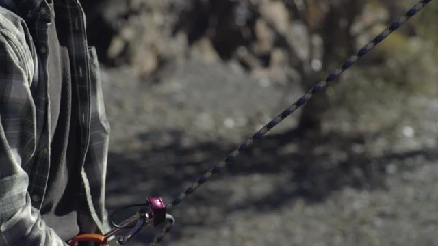 Outdoorsy Young Man Belays His Climbing Partner