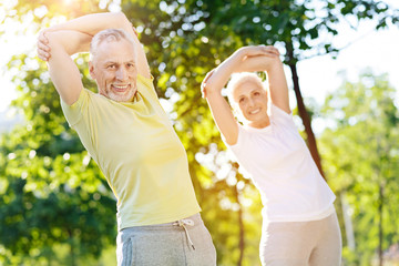 Delighetd retired couple doing sport exercises