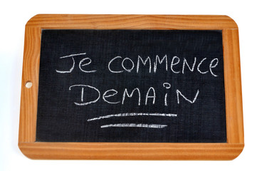 Obraz premium Je commence demain écrit sur une ardoise 