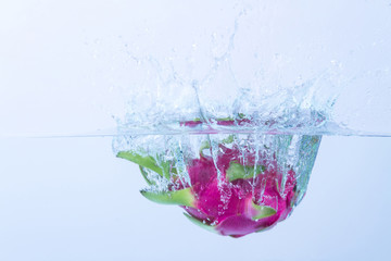 Dragon fruit splashing in water