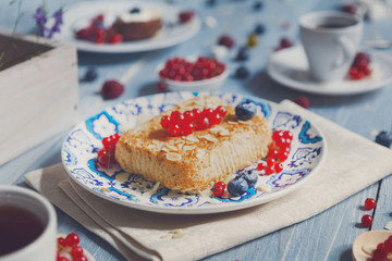 Pastry pie, tea, coffee and berries at blue rustic wood
