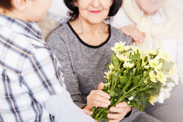 Boy giving flowers to grandparents
