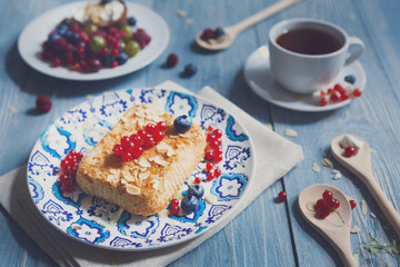 Pastry pie, tea and berries at blue rustic wood