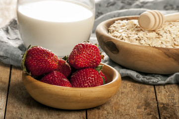 Healthy breakfast concept with oat flakes and fresh berries on rustic background. Food made of granola and musli. Healthy banana smoothie with blackberries, honey and milk.