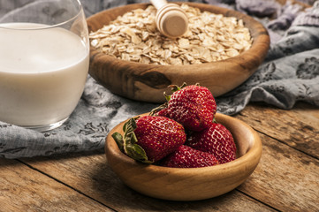 Healthy breakfast concept with oat flakes and fresh berries on rustic background. Food made of granola and musli. Healthy banana smoothie with blackberries, honey and milk.