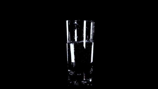 yellow effervescent tablet falling in  glass of water