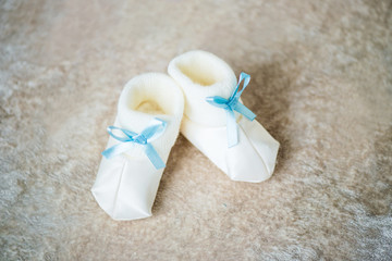 Fototapeta na wymiar Baby booties with blue ribbons. Waiting for the boy.