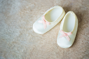 Baby booties with pink ribbons. Waiting for the boy.