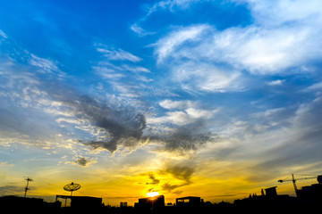 Fototapeta premium Background of sihouette city, sunrise above the roof top, nice weather good blue sky at morning and fuffy cumulus clouds