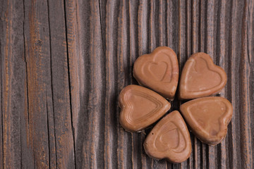 Chocolate heart-shaped candy on wooden background