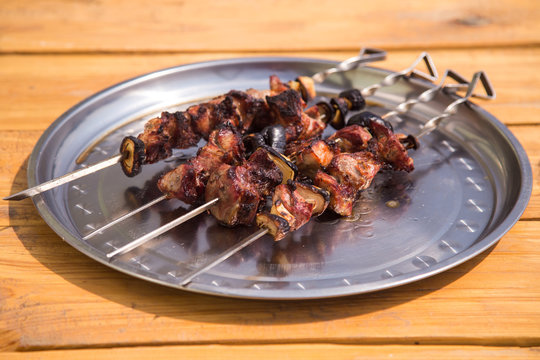 Fried skewers on a dish on a wooden background