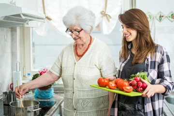 Papier Peint photo autocollant Cuisinier Grand-mère et petite-fille cuisinant ensemble dans la cuisine.