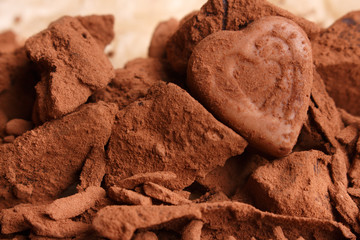 Chocolate heart-shaped candy on a rustic background, chocolate composition