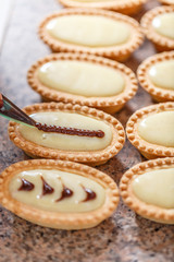 Woman hand decorating mini tarts