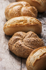 Variety of bread loaves on a white wooden table.