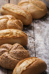 Variety of bread loaves on a white wooden table.