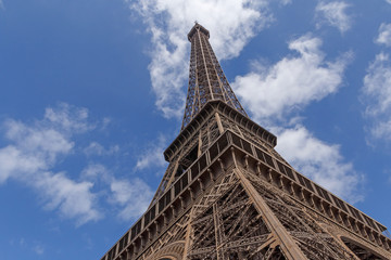 Eiffel tower in Paris against blue sky with white clouds