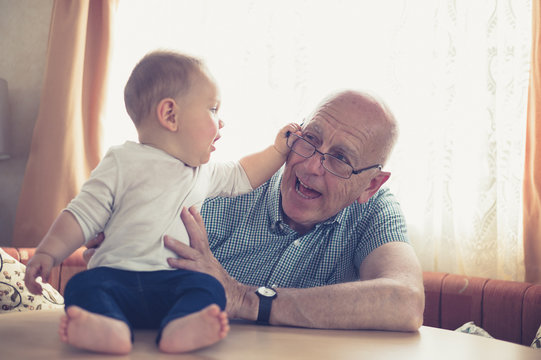 Grandfather playing with baby at table