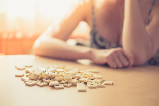 Young woman at table with word game