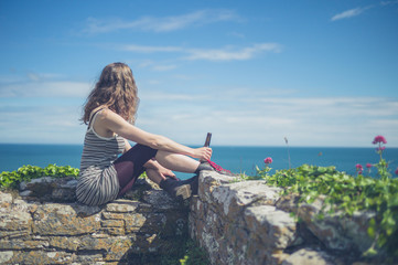 Woman drinking beer by the sea