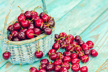 Sweet red fresh cherries in a basket on wooden grunge table