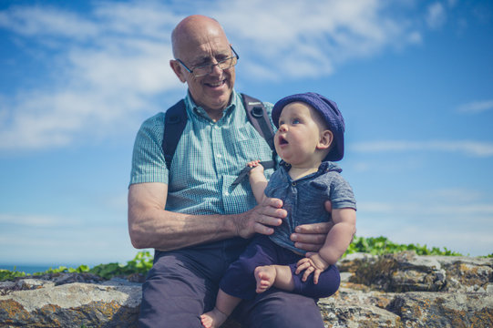 Grandfather playing with grandchild by the sea