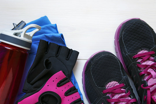 fitness concept equipment- sneakers, workout gloves, water and towel