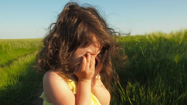 Emotions of the child. Little girl is crying in the field.