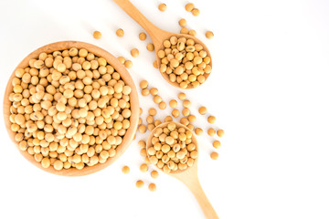 Soybeans in a wooden bowl with wooden spoon on a white background, Top view with copy space and text.
